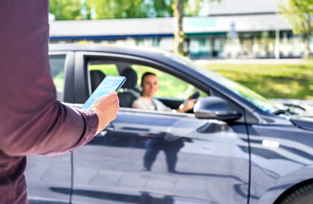 person using rideshare app waits on driver who has just arrived