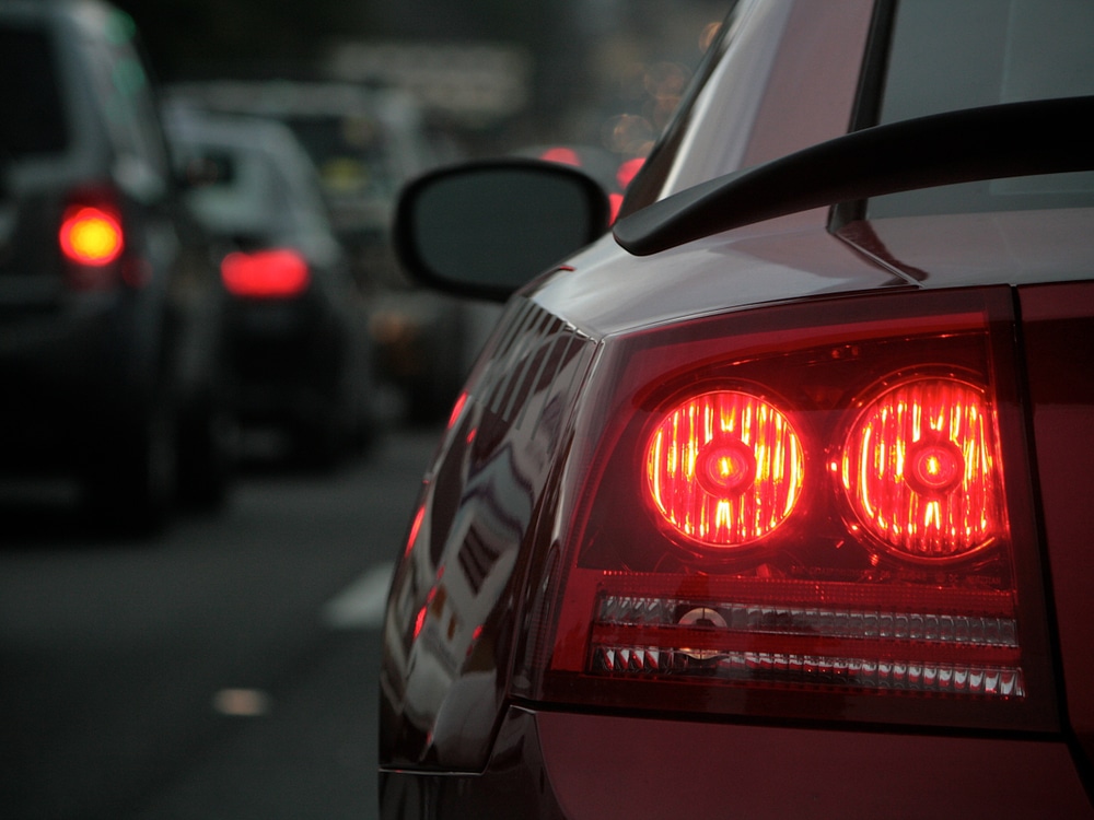 close-up of a car's rear taillight in traffic after work